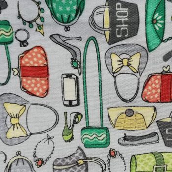 Tela infantil bolsitos gris** de algodón 100% con estampado de bolsos, zapatos y lazos sobre fondo gris de 1,10m de ancho