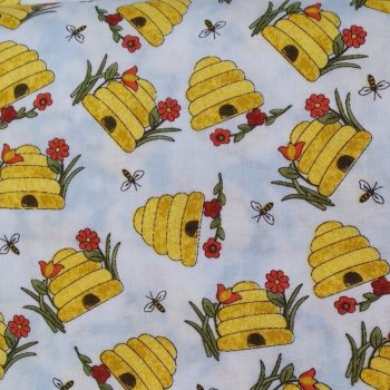 Estampado de tela de algodón azul con diseño de hexágonos tipo colmena que contienen gatos coloridos, flores y ovillos de lana para costura